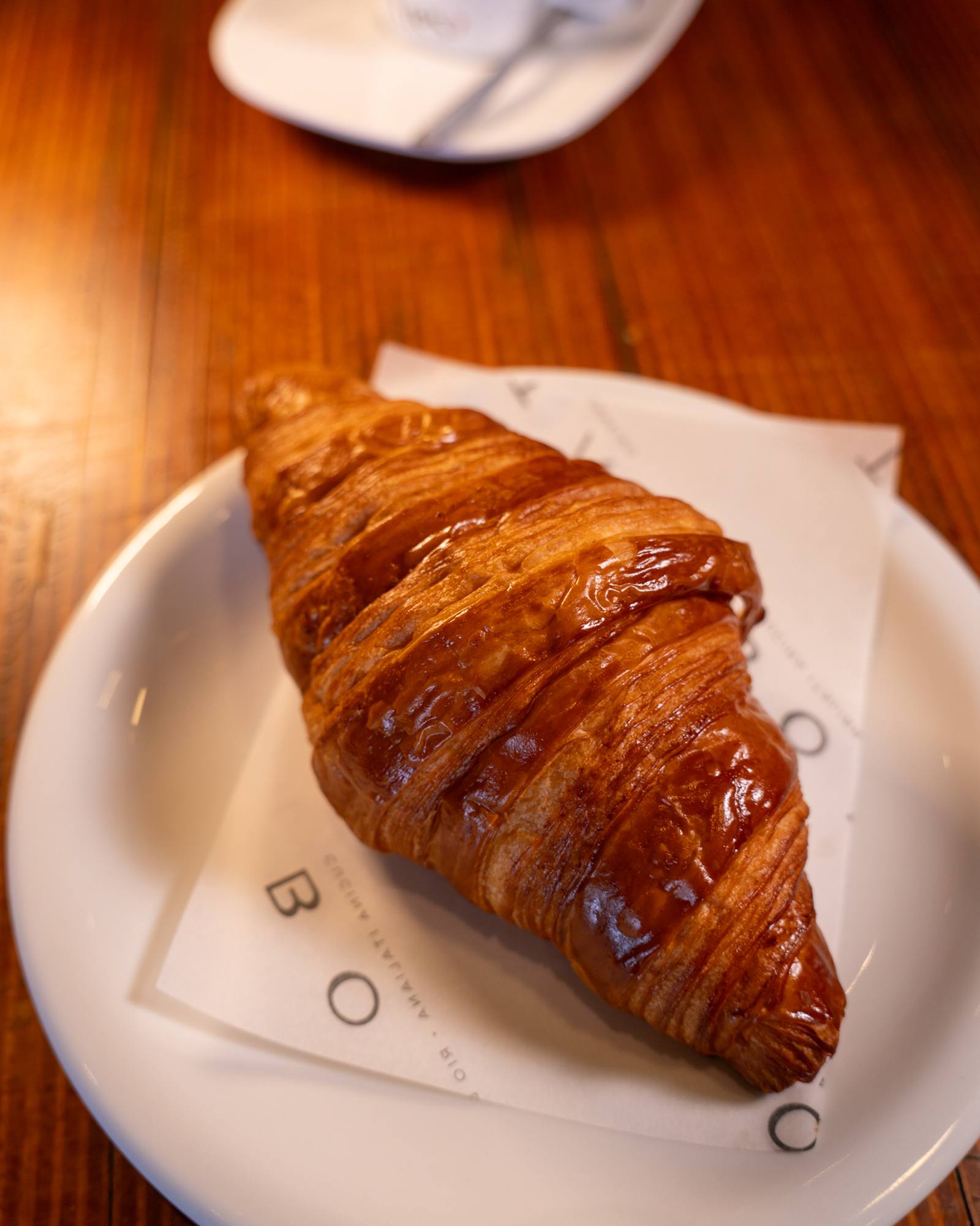 Croissant recém-assado servido com café no BOTA Caffè